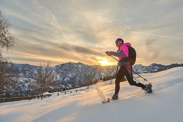young-sporty-woman-downhill-snow-with-snowshoes-sunset-landscape_159805-1380